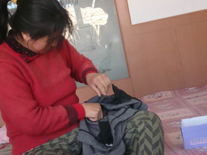 妈妈缝补旧衣服